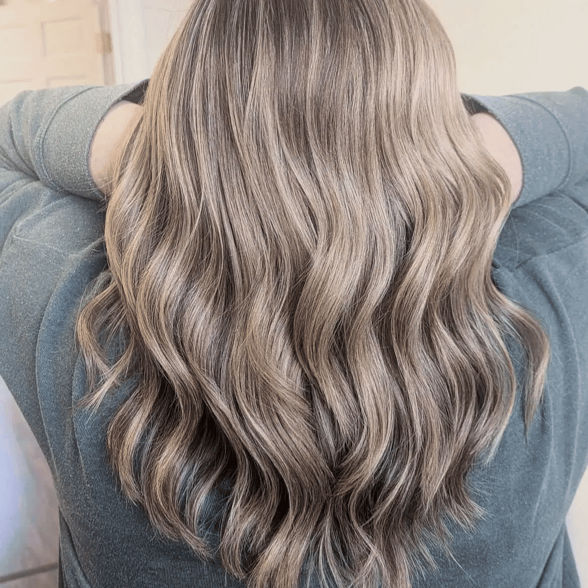 Wavy blond hair cascading over shoulders, viewed from behind.